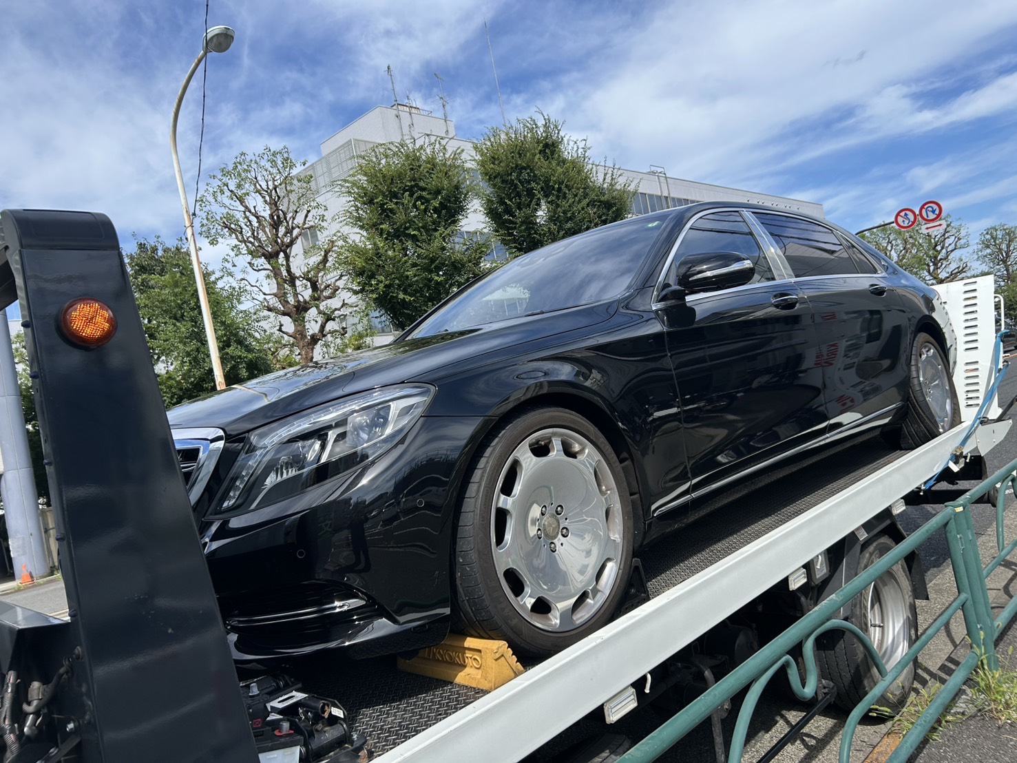 黒いレッカー車がメルセデス・ベンツをディーラーまで搬送している様子